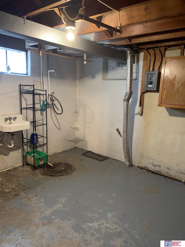 below grade area featuring electric panel and a sink