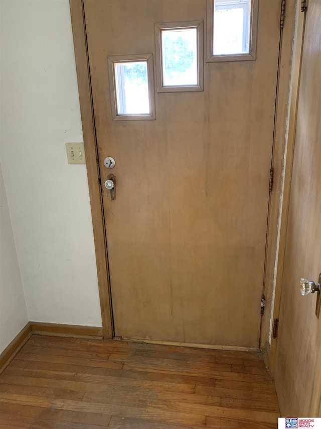 doorway featuring light wood-type flooring and baseboards