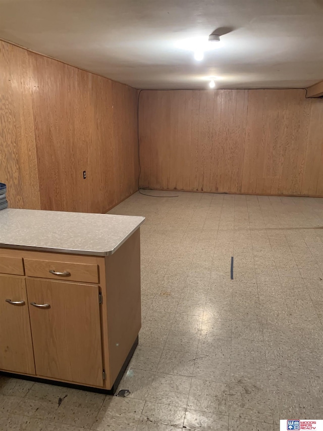 finished basement featuring wood walls and light floors