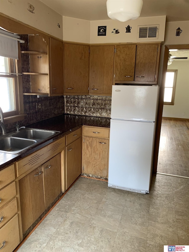 kitchen with visible vents, dark countertops, backsplash, and freestanding refrigerator