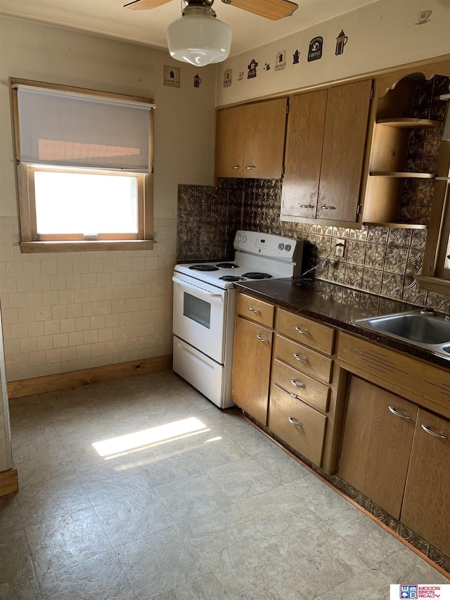 kitchen featuring white electric stove, brown cabinetry, a ceiling fan, dark countertops, and light floors