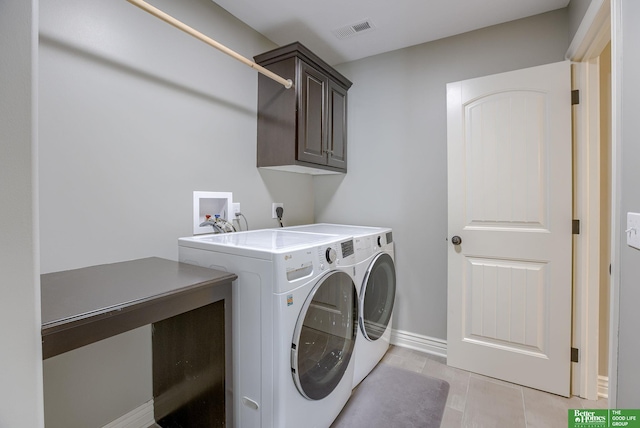 clothes washing area with visible vents, baseboards, washer and clothes dryer, light tile patterned flooring, and cabinet space