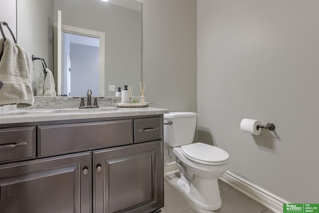 bathroom featuring tile patterned floors, baseboards, toilet, and vanity