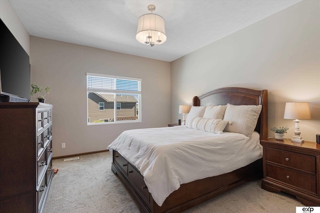 bedroom with light carpet, visible vents, and baseboards