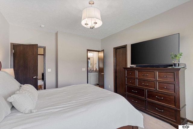 bedroom featuring light colored carpet and ensuite bathroom