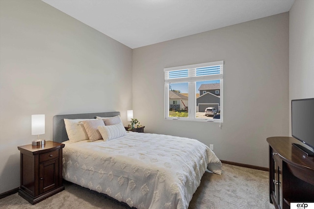 bedroom featuring light carpet and baseboards