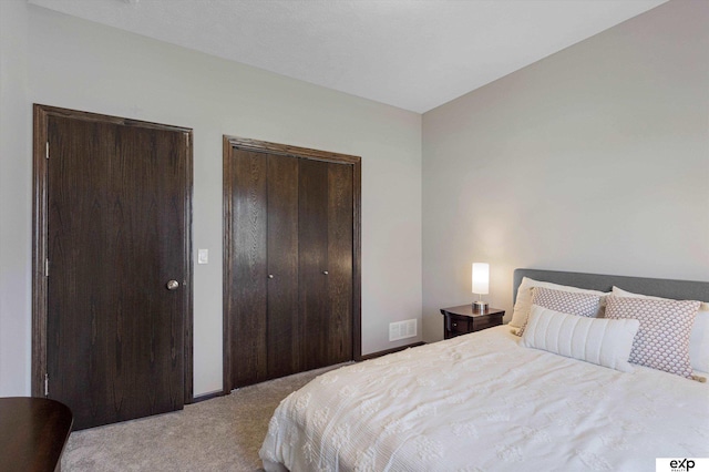 bedroom with visible vents and light colored carpet