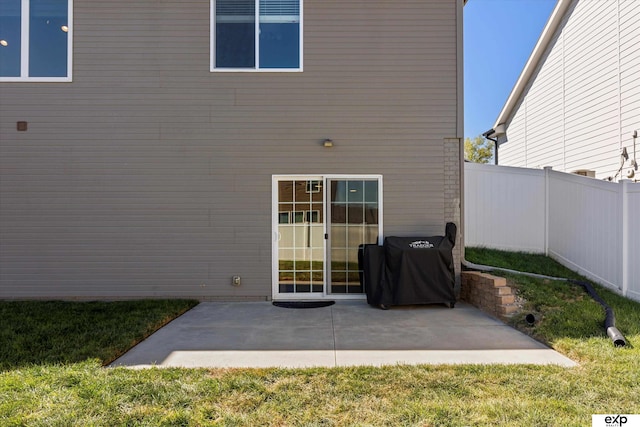 rear view of property with a patio, a lawn, and fence