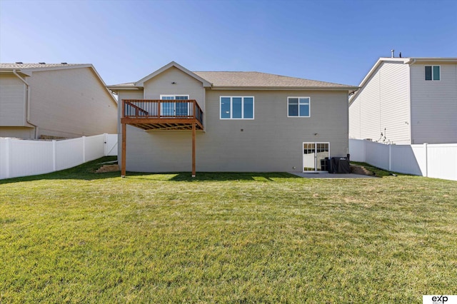 rear view of house featuring a fenced backyard, a deck, and a yard