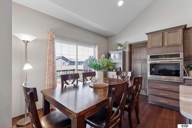 dining room with baseboards, vaulted ceiling, and dark wood-type flooring