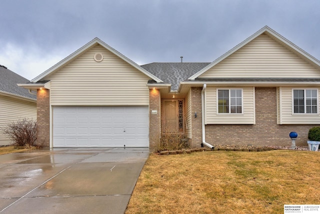 single story home featuring an attached garage, brick siding, a shingled roof, concrete driveway, and a front yard