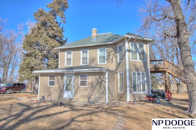 back of property featuring stairs, a deck, and a chimney