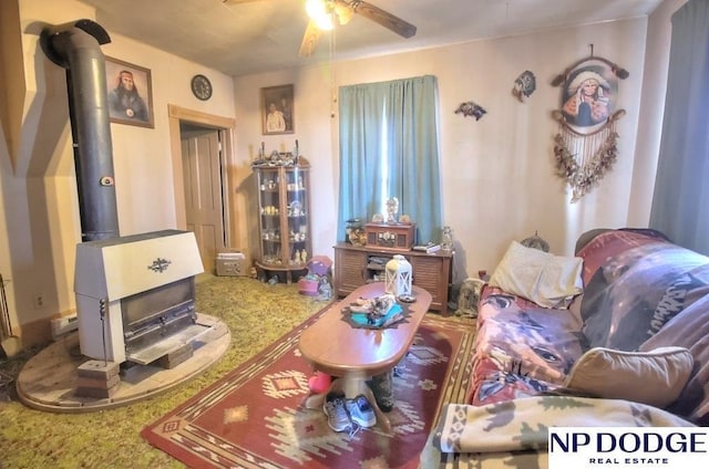 living room featuring ceiling fan and a wood stove