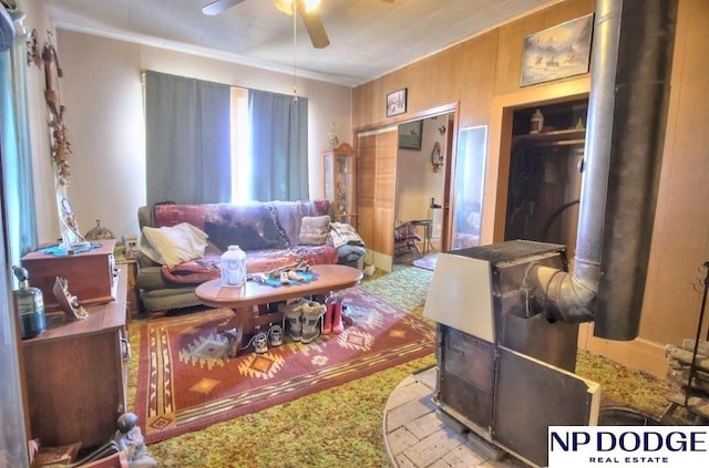 living area with ornamental molding and a ceiling fan