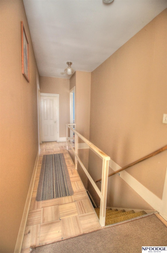 corridor with baseboards and an upstairs landing