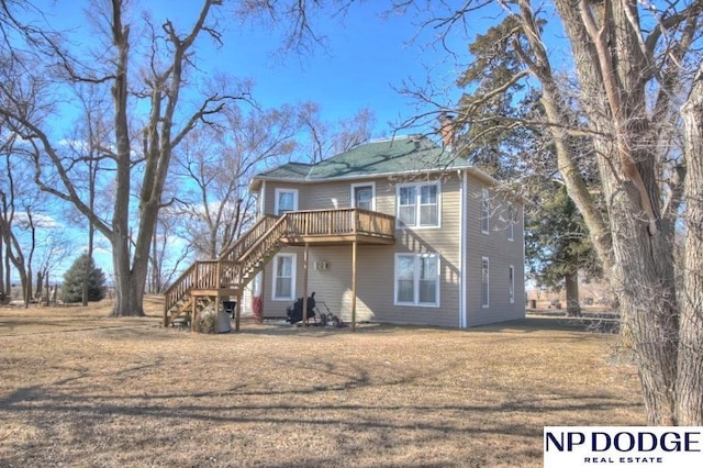 back of property featuring a yard, a chimney, stairway, and a wooden deck