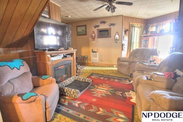 living area with ceiling fan and a glass covered fireplace