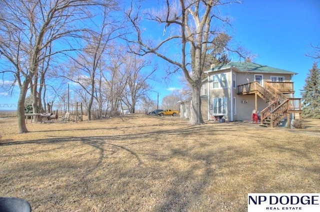 view of yard featuring a deck and stairway