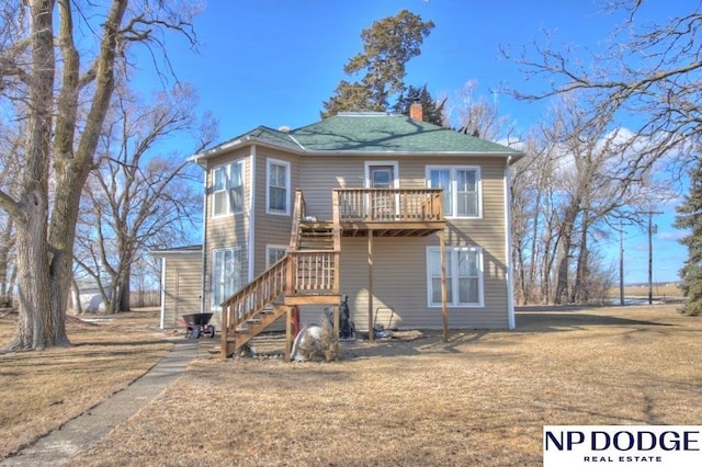 view of front of house with a chimney, stairway, and a wooden deck