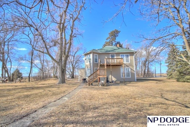 view of front facade with a front yard, a chimney, and stairs