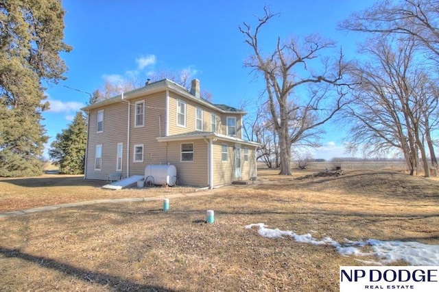 view of property exterior featuring a chimney and heating fuel