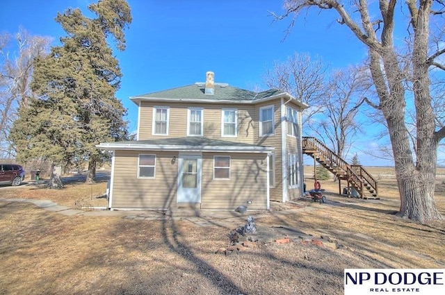 rear view of house with entry steps and stairway