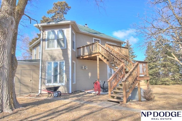 rear view of property with a deck and stairs