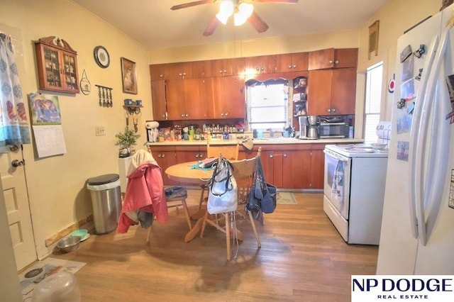 kitchen featuring a ceiling fan, white appliances, light countertops, and wood finished floors