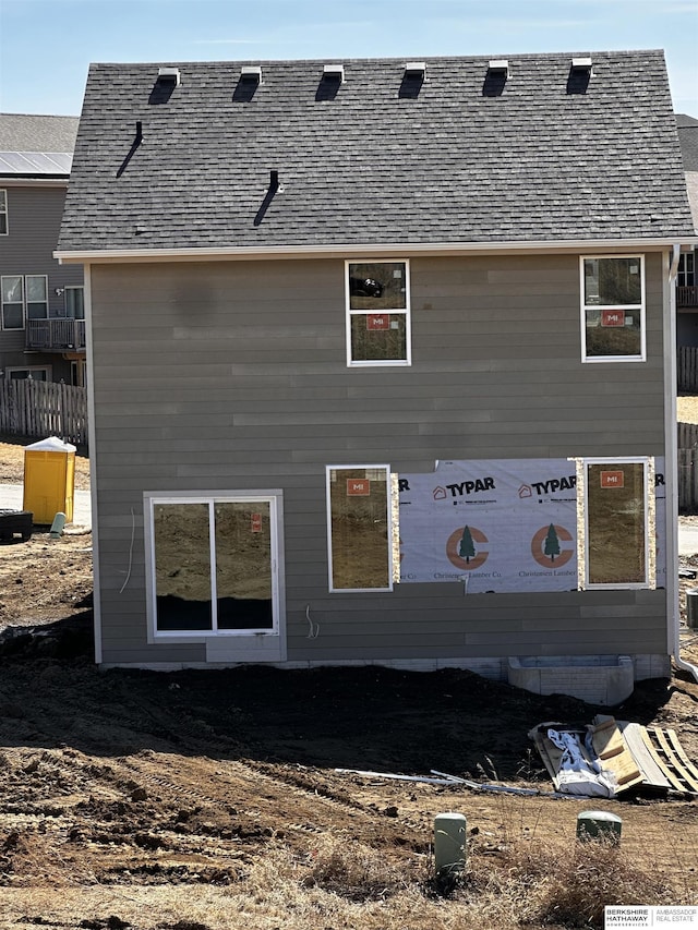 back of house with a shingled roof