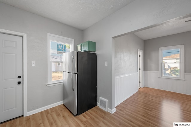 kitchen featuring visible vents, plenty of natural light, freestanding refrigerator, and green cabinetry