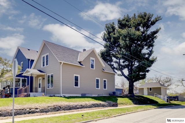 view of property exterior featuring a lawn, roof with shingles, and cooling unit