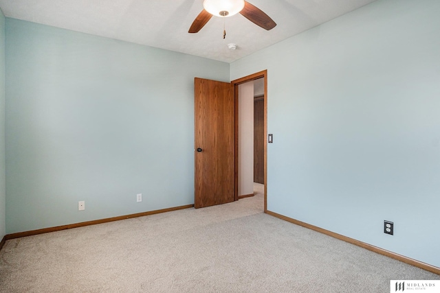 unfurnished room featuring a ceiling fan, light colored carpet, visible vents, and baseboards