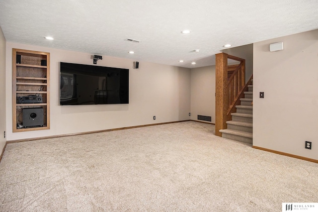 unfurnished living room with carpet floors, a textured ceiling, and baseboards