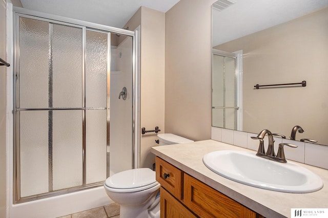 bathroom featuring visible vents, a stall shower, vanity, and toilet