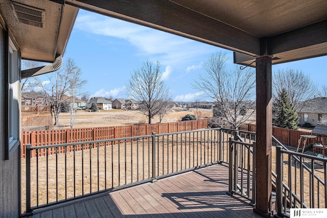 wooden deck featuring a residential view, a fenced backyard, and visible vents