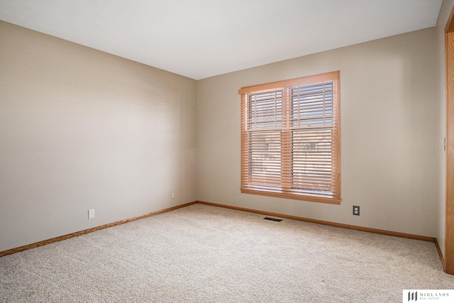 carpeted empty room with visible vents and baseboards