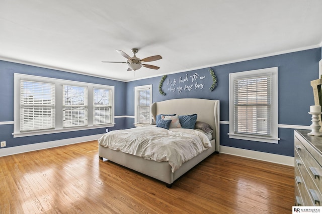 bedroom with wood-type flooring, crown molding, baseboards, and ceiling fan