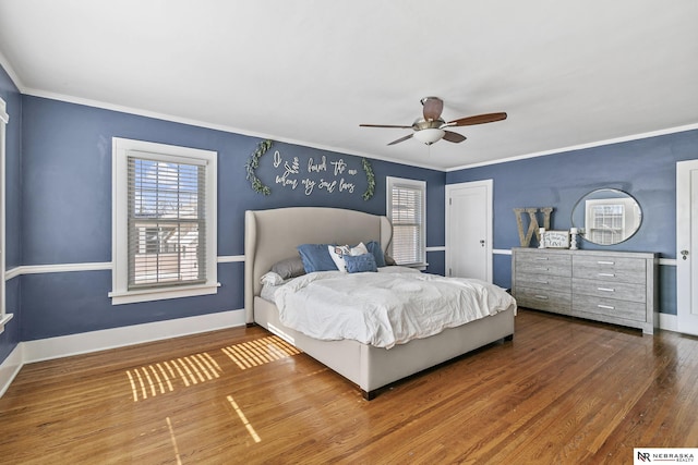 bedroom with baseboards, ceiling fan, ornamental molding, wood finished floors, and a closet