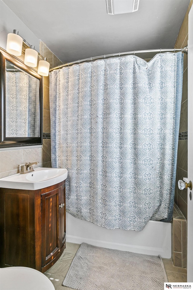 full bath with tile patterned flooring, visible vents, vanity, tile walls, and decorative backsplash