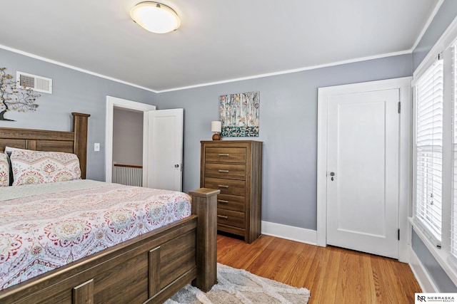 bedroom with light wood-style floors, multiple windows, visible vents, and crown molding