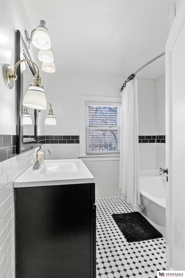 full bathroom featuring wainscoting, tile walls, vanity, and shower / bath combo with shower curtain