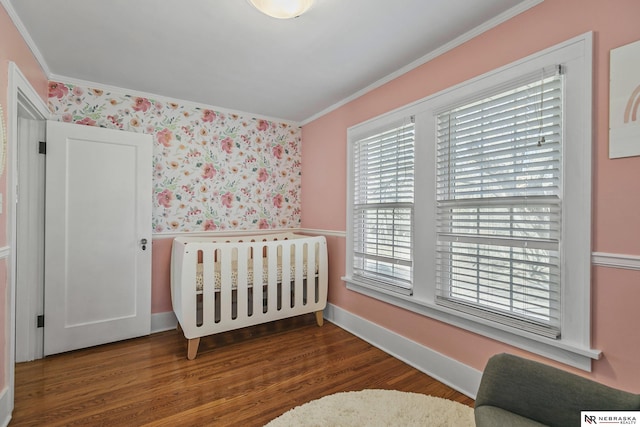 bedroom with dark wood-style floors, baseboards, and crown molding