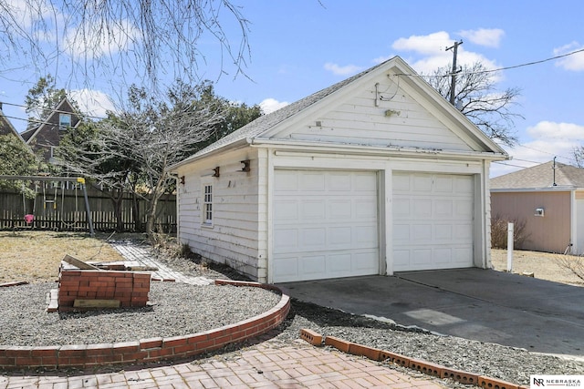 detached garage featuring fence