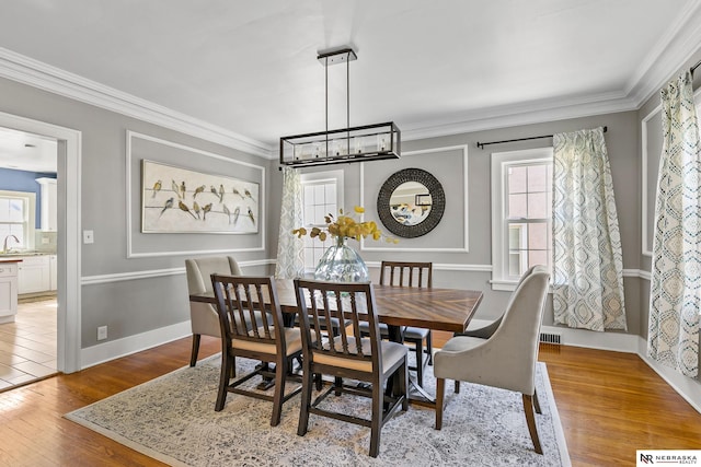 dining space featuring light wood-style floors and ornamental molding