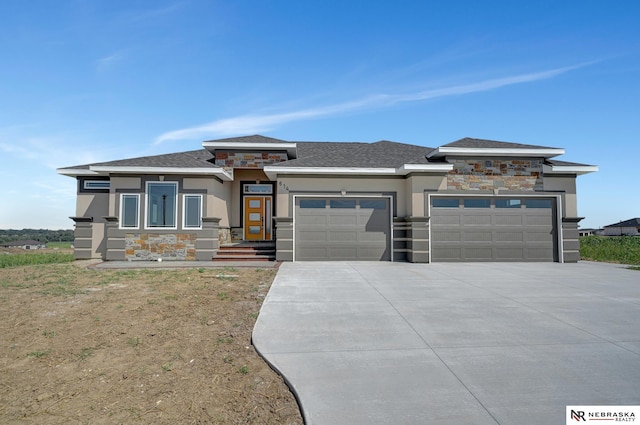 prairie-style home featuring a garage, stone siding, driveway, and stucco siding