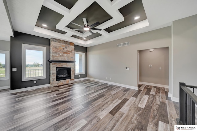 unfurnished living room featuring baseboards, visible vents, coffered ceiling, wood finished floors, and a fireplace