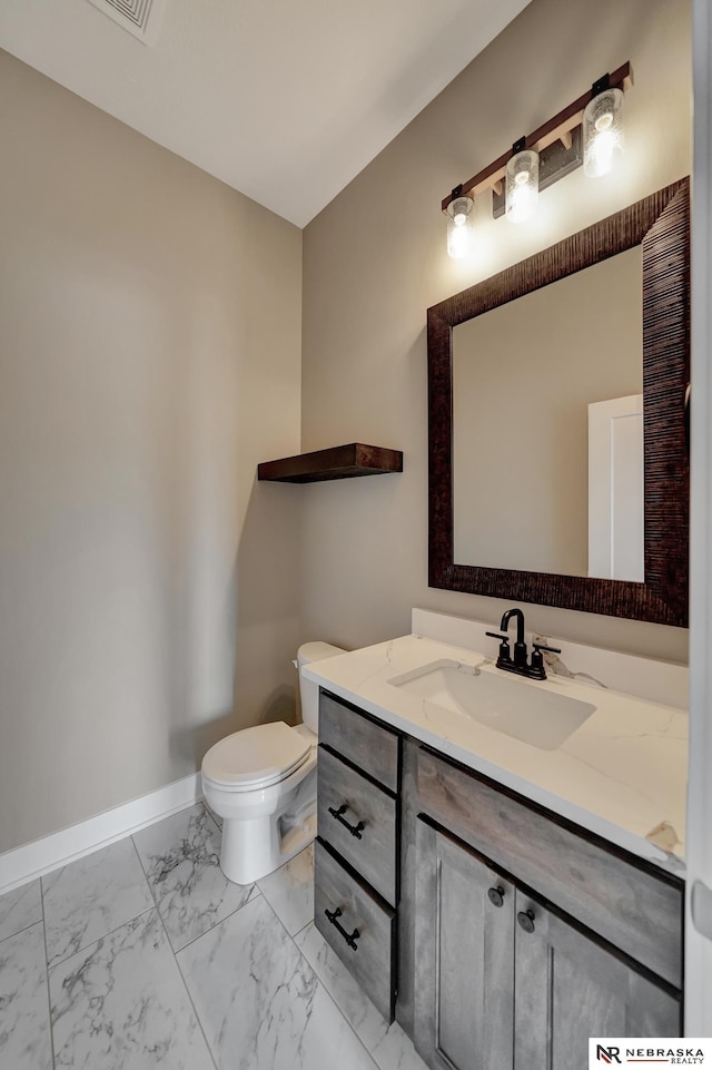 bathroom featuring marble finish floor, toilet, vanity, and baseboards