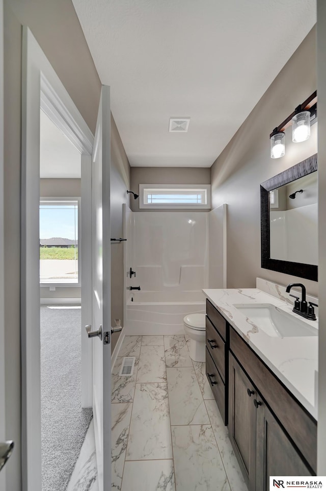 full bathroom featuring toilet, vanity, visible vents, marble finish floor, and washtub / shower combination