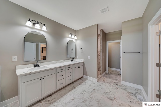 full bath featuring marble finish floor, baseboards, visible vents, and a sink