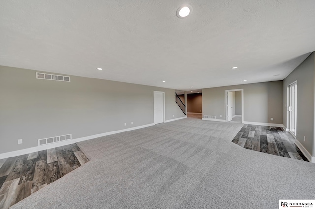 unfurnished living room with baseboards, stairs, visible vents, and recessed lighting